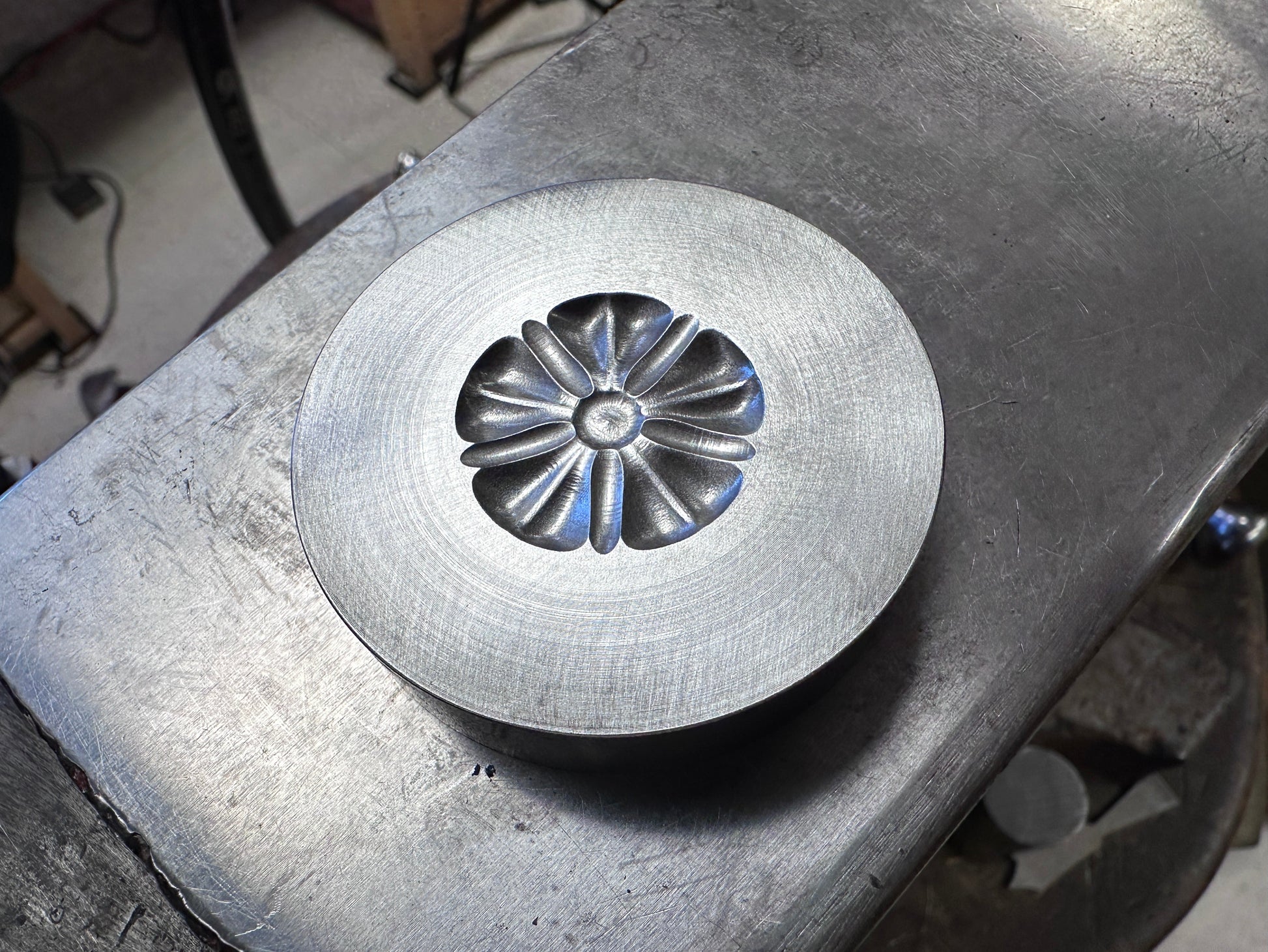 Metal die with floral design on a metal surface